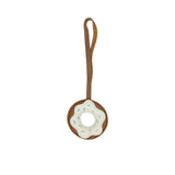 A handcrafted brown leather donut-shaped bag charm by MUNI, featuring white leather frosting, colorful embroidered sprinkles.