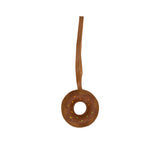A handcrafted brown leather donut-shaped bag charm by MUNI, featuring white leather frosting, colorful embroidered sprinkles.