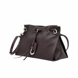 Side-angled view of a brown leather MUNI shoulder bag with tassel details, showcased by BLUE SALON.