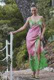 Pink satin maxi slip dress with spaghetti straps, green lace V-neck trim, and green leaf lace on bodice, high slit, and hem.