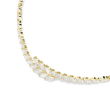 A macro three-quarter perspective shot focusing on the asymmetric centerpiece of the Swarovski Mesmera necklace, where the white marquise crystals overlap beautifully in their gold-plated claw settings.