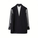Back studio view of the black Nenette blazer showcasing the solid lower torso and a prominent semi-sheer mesh panel forming a V-shape on the upper back.