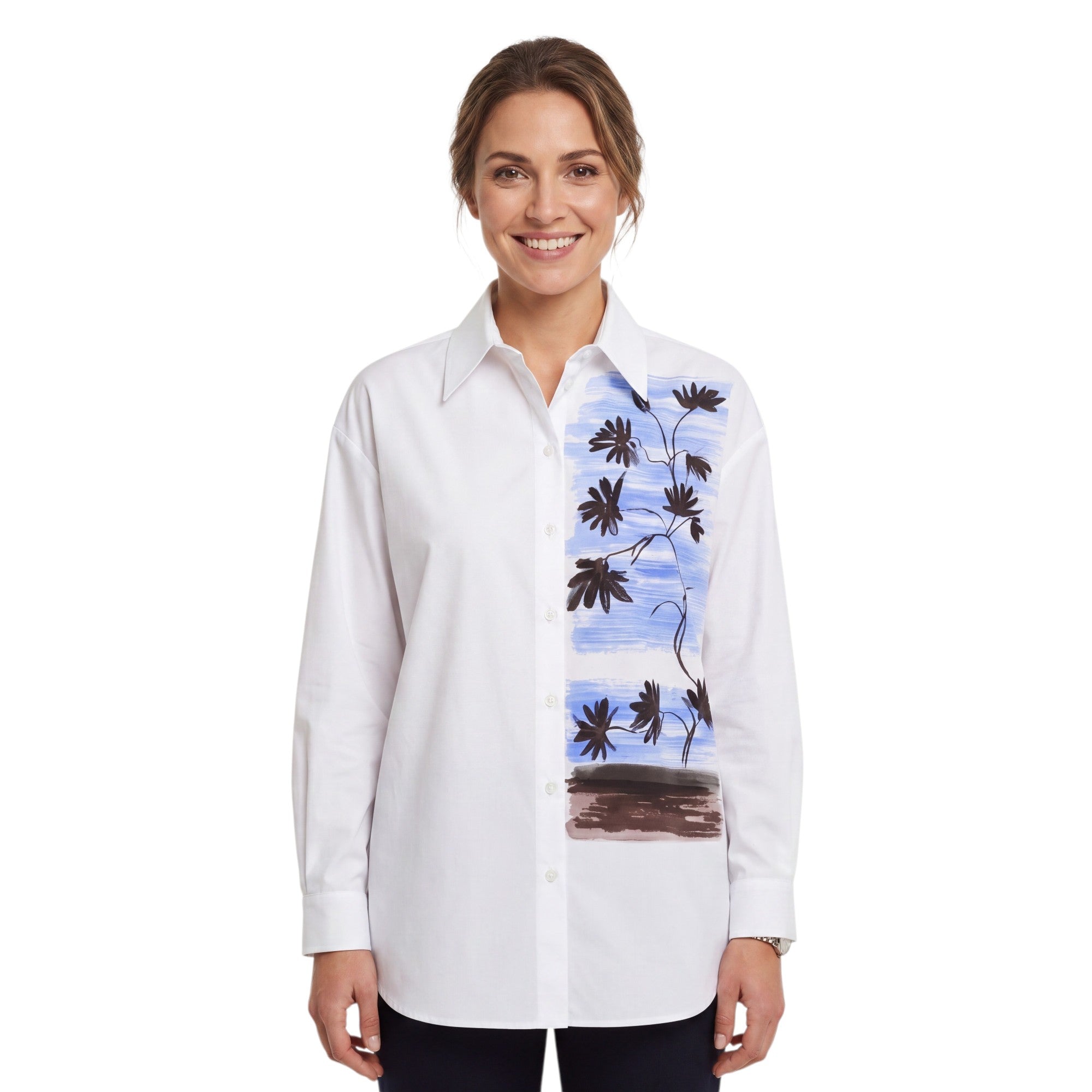 Front view of a smiling woman with her hair tied back wearing the white Nenette button-down shirt with the artistic floral graphic print, paired with dark pants.