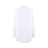 Back studio view of the white Nenette shirt showing its clean, plain fabric, relaxed structure, dropped shoulders, and slightly curved high-low hem.