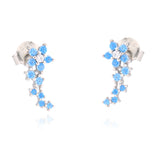 Pair of silver-toned stud earrings, each with a top flower of light blue stones around a clear stone, and a curved trail of b