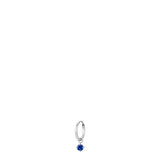 Silver-toned steel hoop earring with a dangling round blue zircon in a silver-toned setting.