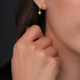 Side lifestyle view displaying the delicate gold-plated Cerruti 1881 Francesca logo stud earring styled elegantly on a model's ear.