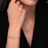Lifestyle portrait of a model wearing the delicate gold-plated Cerruti 1881 Amalia double C pendant necklace against a black square neckline.
