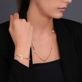 Lifestyle studio photograph showcasing the delicate scale, fit, and high-shine gold luxury aesthetic of the Celeste bracelet on a model's wrist.