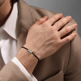 Lifestyle product shot displaying the fit, scale, and metallic shine of the men's Cerruti 1881 Guido IP black steel bracelet worn on a wrist.