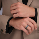 Lifestyle product photograph displaying the robust fit, scale, and polished silver finish of the Paolo ring on a man's hand.