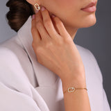 Side profile lifestyle image showcasing the fit, scaling, and high-intensity sparkle of the Cerruti 1881 Bianca gold crystal logo earrings on a model.
