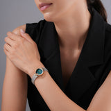 A lifestyle model shot displaying the 24mm Escada watch worn elegantly on a female wrist, paired with a black tailored sleeveless top to emphasize its jewelry-like wrist presence.