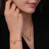 Lifestyle studio photo showcasing the fit, scaling, and high-shine gold polish of the Cerruti 1881 Isadora round logo bracelet on a woman's wrist.