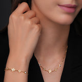 Lifestyle studio portrait of a model wearing the delicate Cerruti 1881 Francesca 5-motif gold necklace against a clean neckline.