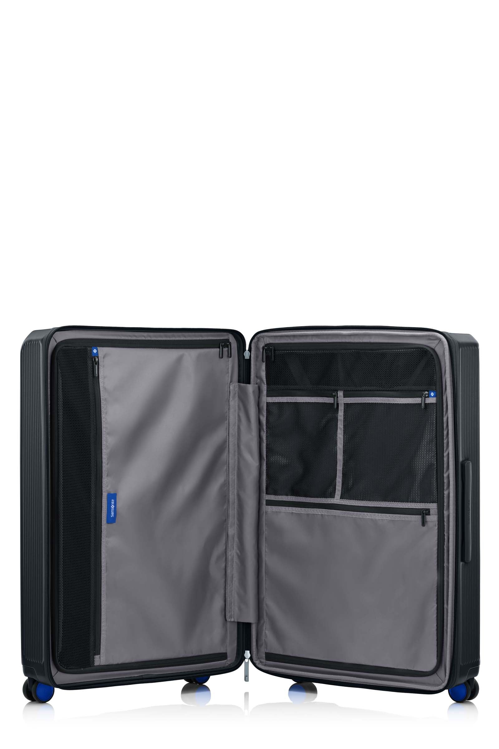 Open interior of the Samsonite Voypod Spinner large in Black, revealing the grey recycled fabric lining, height-adjustable packing straps, and dual zippered divider pads. Shop Online Today