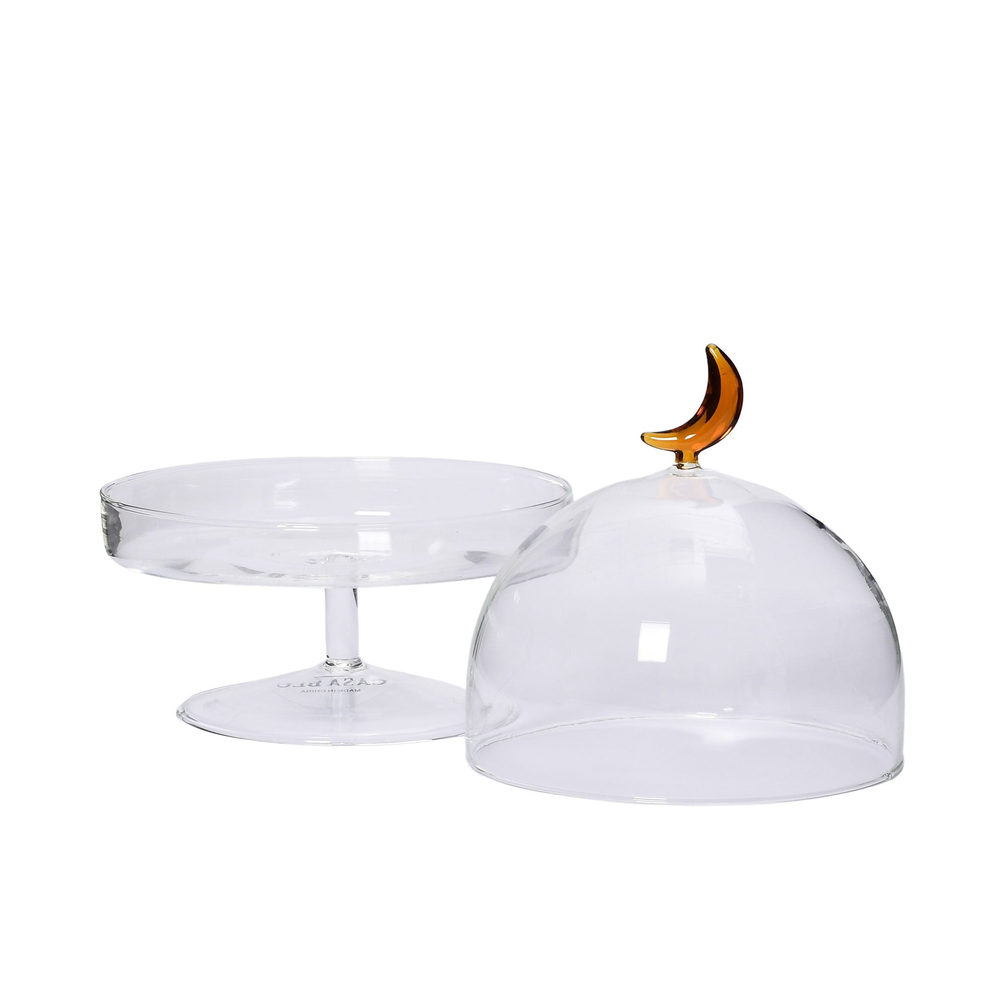 Open lid view of the Favorite Glass clear cake stand with glass dome and amber moon handle. Shop Now Online
