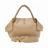 Rear studio view of the beige leather handbag showing the clean leather back panel, stitched center tab, braided handles, and unattached matching leather shoulder strap laid in front, available at BLUE SALON.