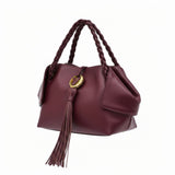 Right three-quarter studio view highlighting the rich burgundy leather texture, structured base, elegant side wing panels, and braided top handles of the luxury handbag, available at BLUE SALON.