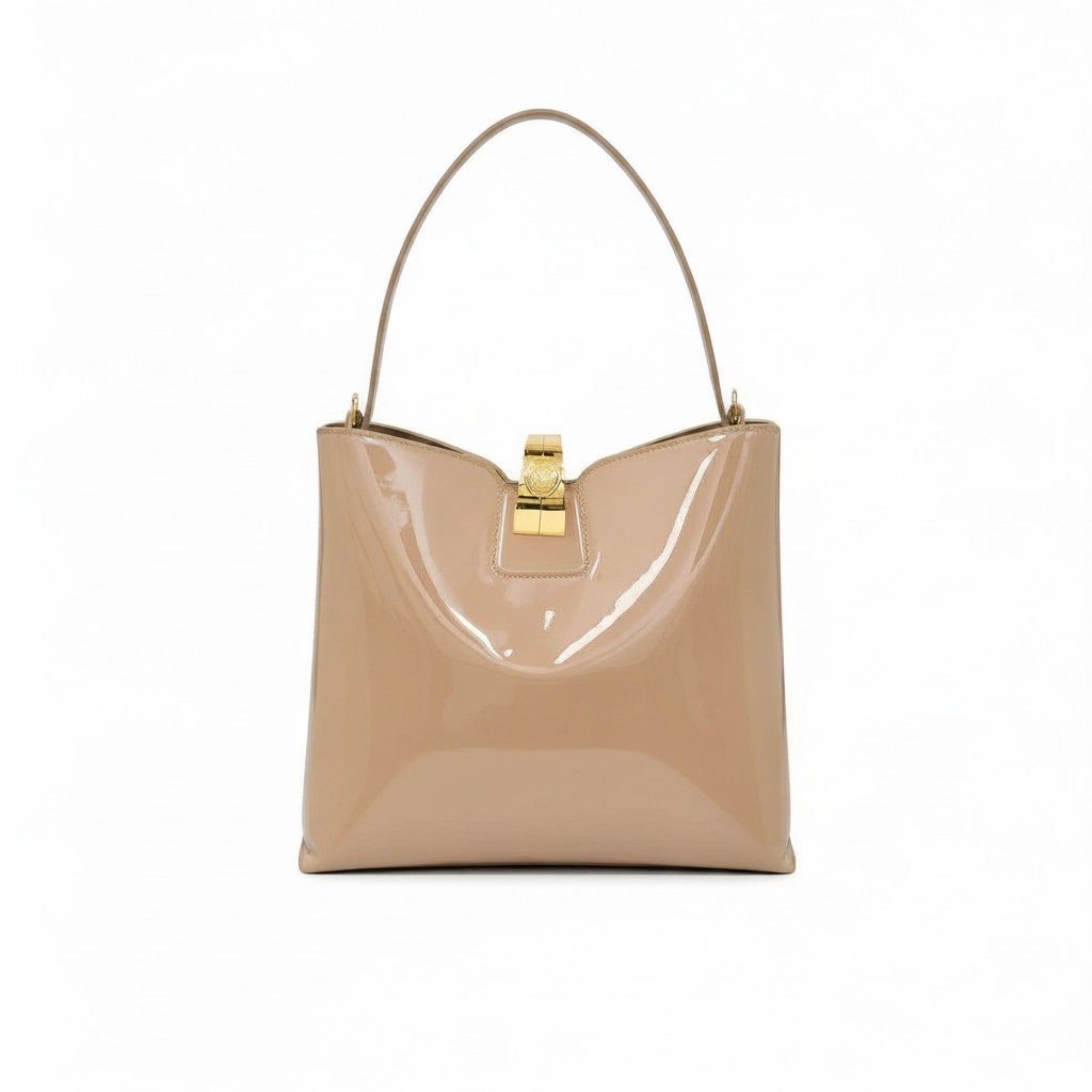 Front view of the beige patent leather bag styled with its wide, detachable matching shoulder strap attached.