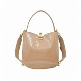 Front view of a beige patent leather shoulder bag with a gold-tone clasp closure, available at Blue Salon.