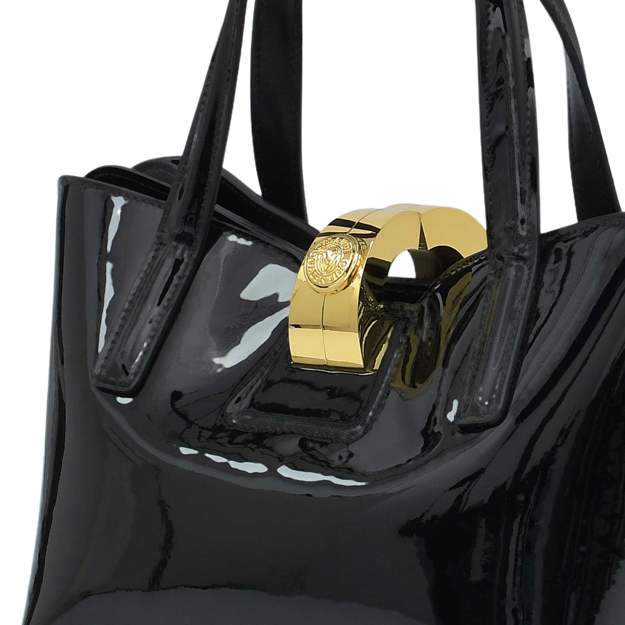 Black patent leather handbag with a gold clasp on a white background.