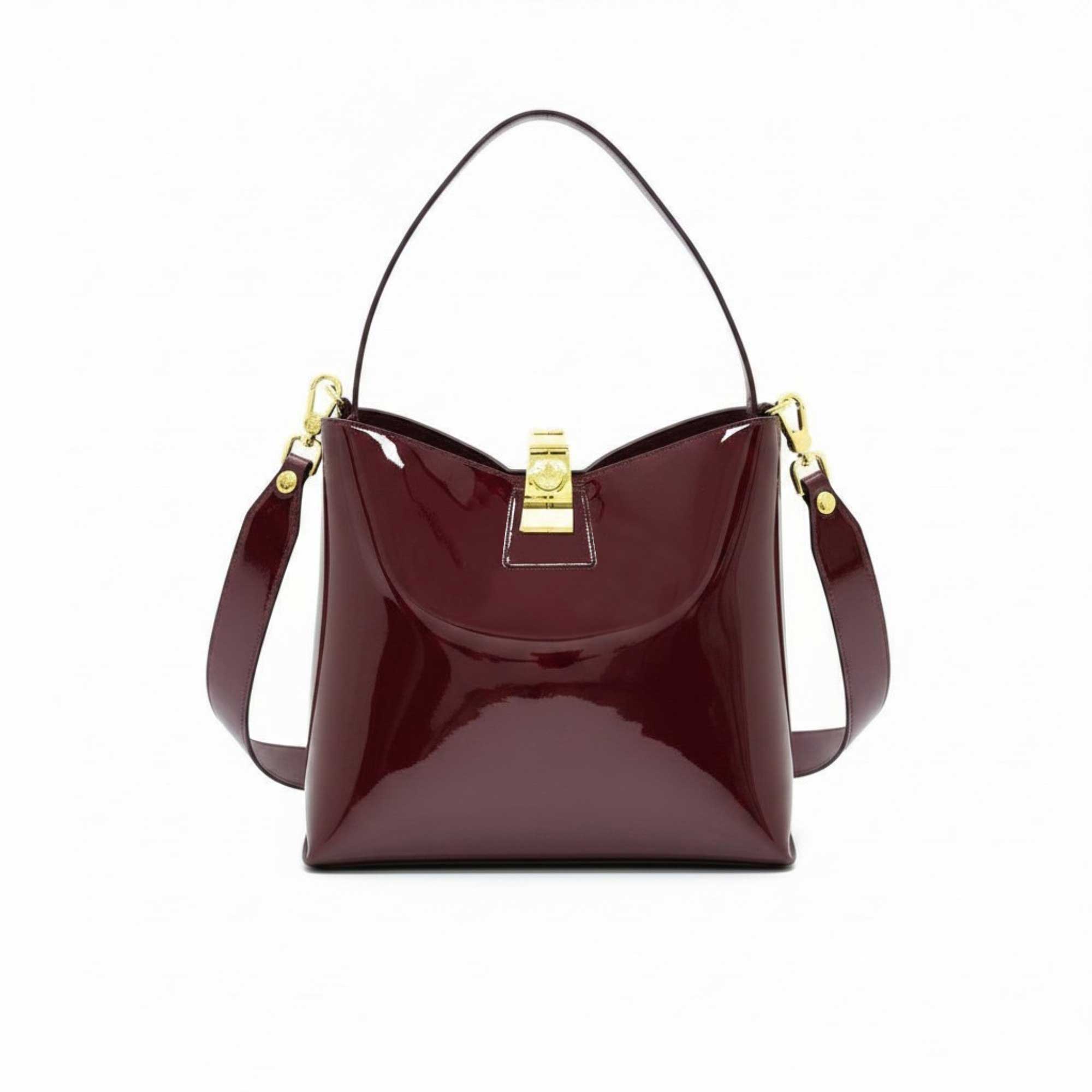 Front view of a burgundy patent leather shoulder bag with a gold-tone clasp closure, available at Blue Salon.