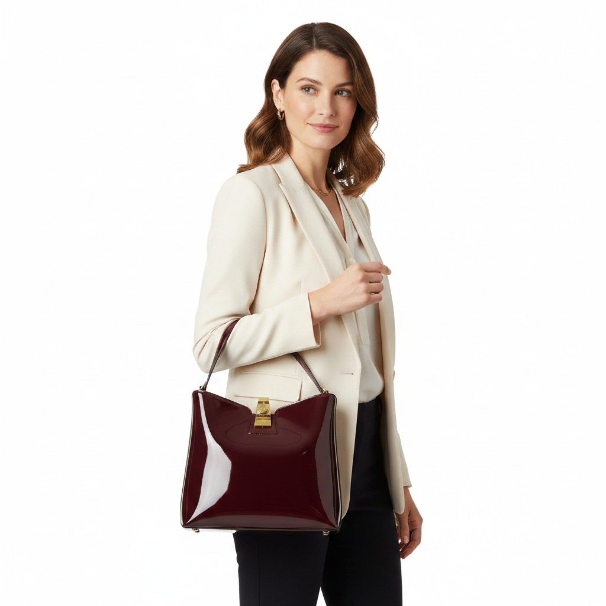 Woman holding a burgundy handbag against a white background.
