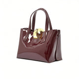 Three-quarter right angle view of the glossy burgundy handbag, showcasing its reflective patent finish and structured side gusset.