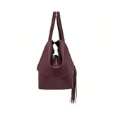 Side profile view of the burgundy leather handbag showing the depth of the folded gusset and the gold-tone top zipper closure.
