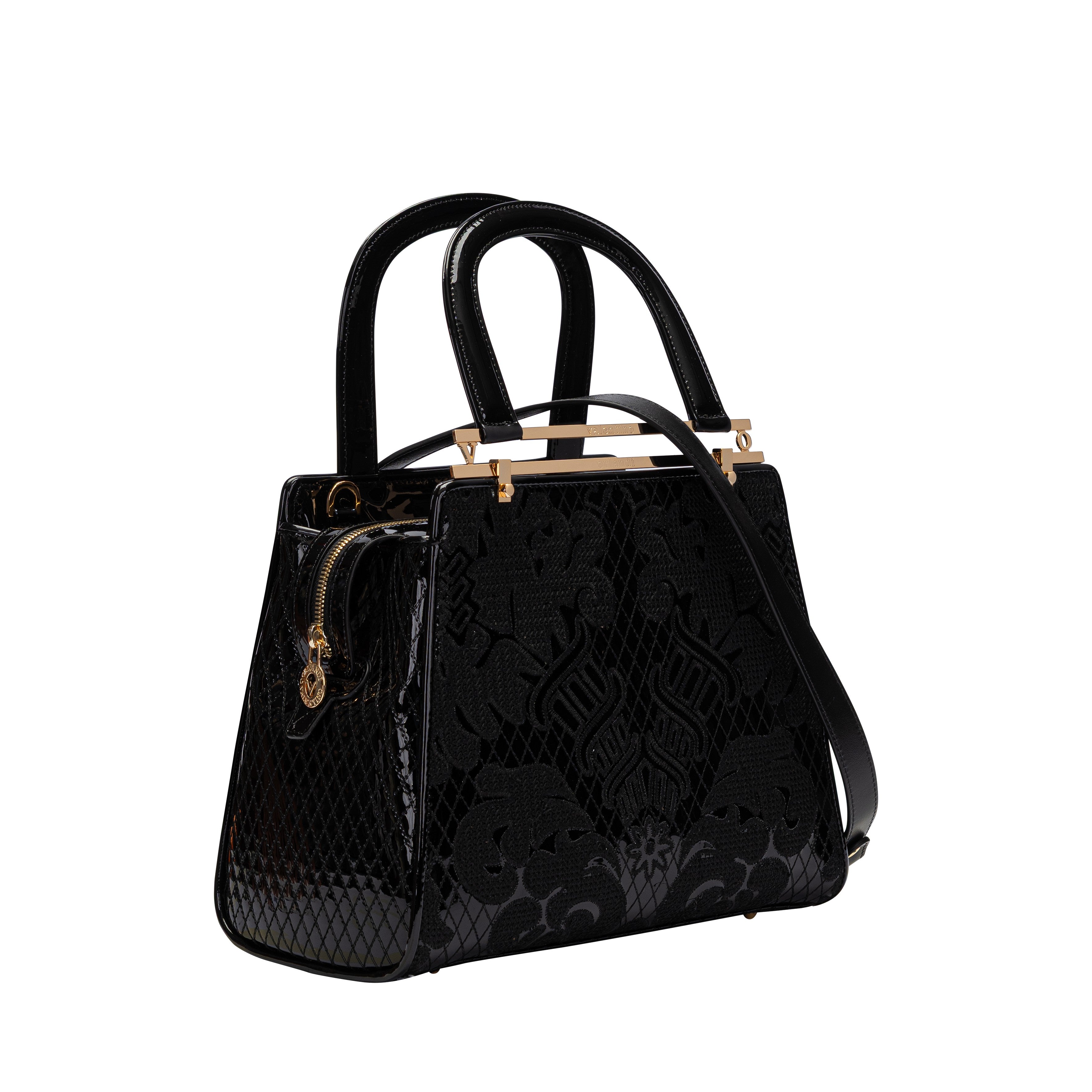 Side view showing the structured trapezoidal shape, gold-tone zippers, and the detachable black leather shoulder strap.