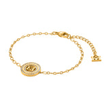 A full layout studio product photograph of the Escada Alice bracelet, showcasing the high-polish gold-plated cable chain, the central crystal-halo monogram medallion, and the lobster clasp closure.