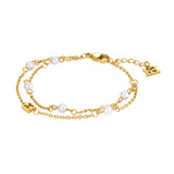 An overview studio product photograph of the Escada Florence double-chain bracelet, showing the gold-plated cable strands, interspersed white pearls, the cutout monogram charm, and the lobster clasp with logo tag extension.
