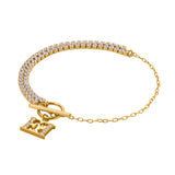 A full three-quarter studio presentation of the Escada Diana bracelet, showcasing the asymmetric half-and-half layout with a double-row crystal tennis track, a gold-plated link chain, and a crystal-accented monogram toggle clasp.