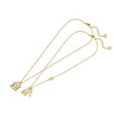 A full layout shot of the complete Escada Minna "Mom & Me" matching necklace set, displaying both gold-plated chains, the respective lock and key pendants, and the dual adjustable extension tracks.