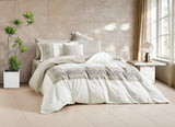 Full bedroom scene with white embroidered duvet set and minimalist decor.