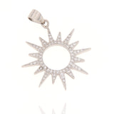 Silver-toned sunburst charm with a central circular cutout and pointed rays, pavé-set with clear cubic zirconia stones.