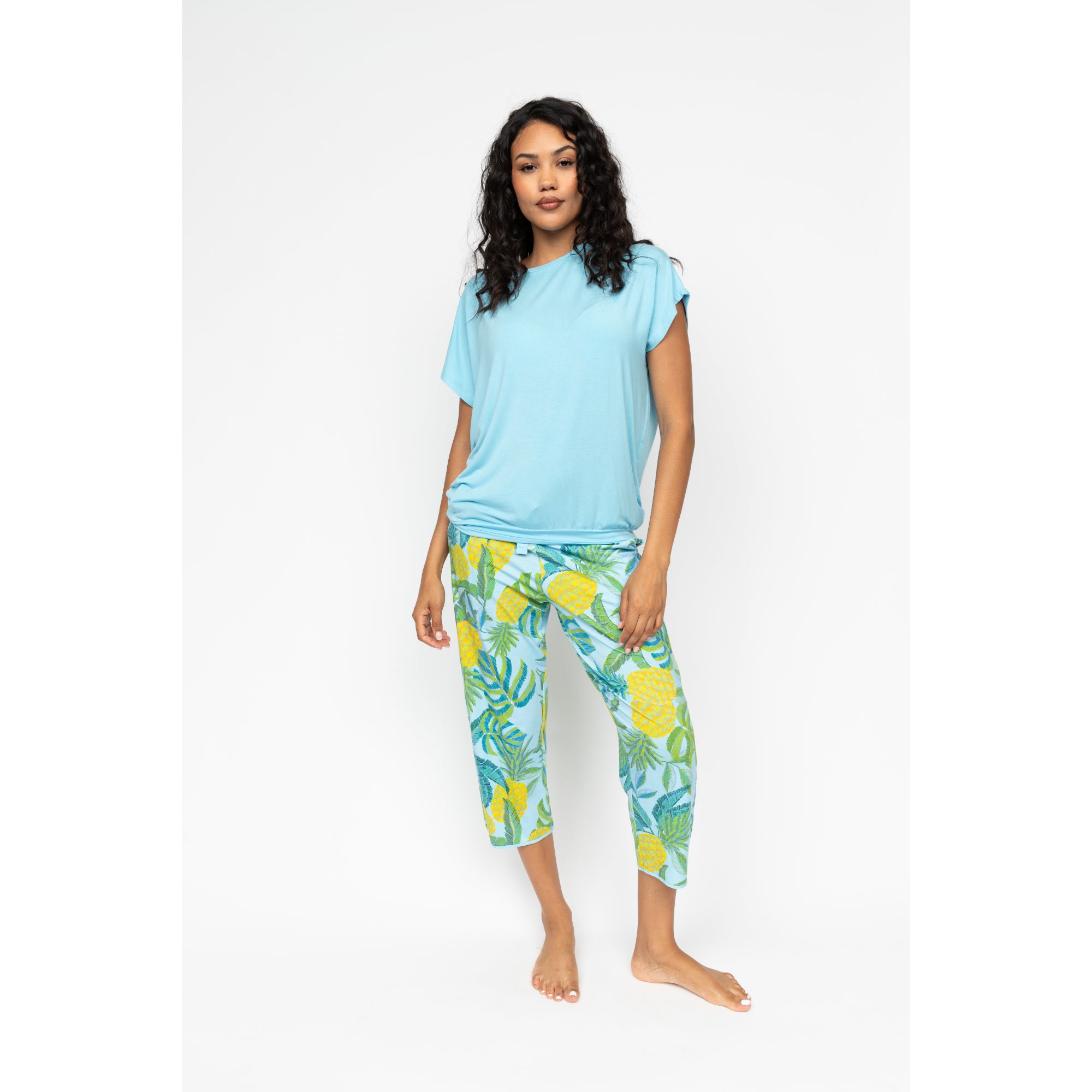 Blue jersey cropped pyjama bottoms with a yellow and green pineapple and leaf print.
