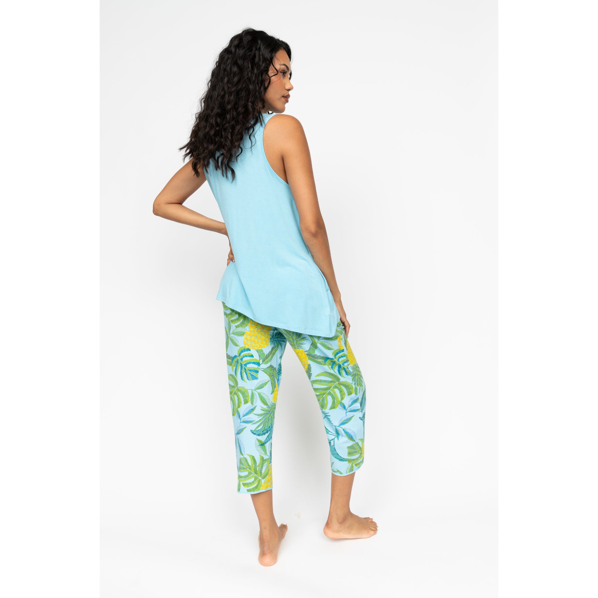 Blue jersey cropped pyjama bottoms with yellow pineapple and green tropical leaf print.