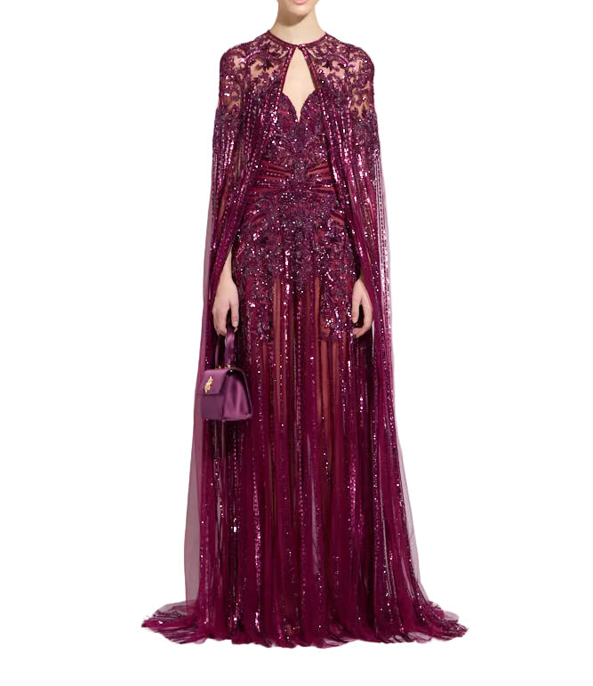 Deep purple embellished floor-length gown with a matching sheer, sequin-covered shoulder cape and V-neckline.