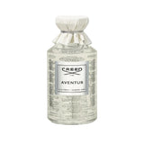 Clear glass CREED Millesime Aventus fragrance bottle with off-white fabric neck cover and silver-toned label.