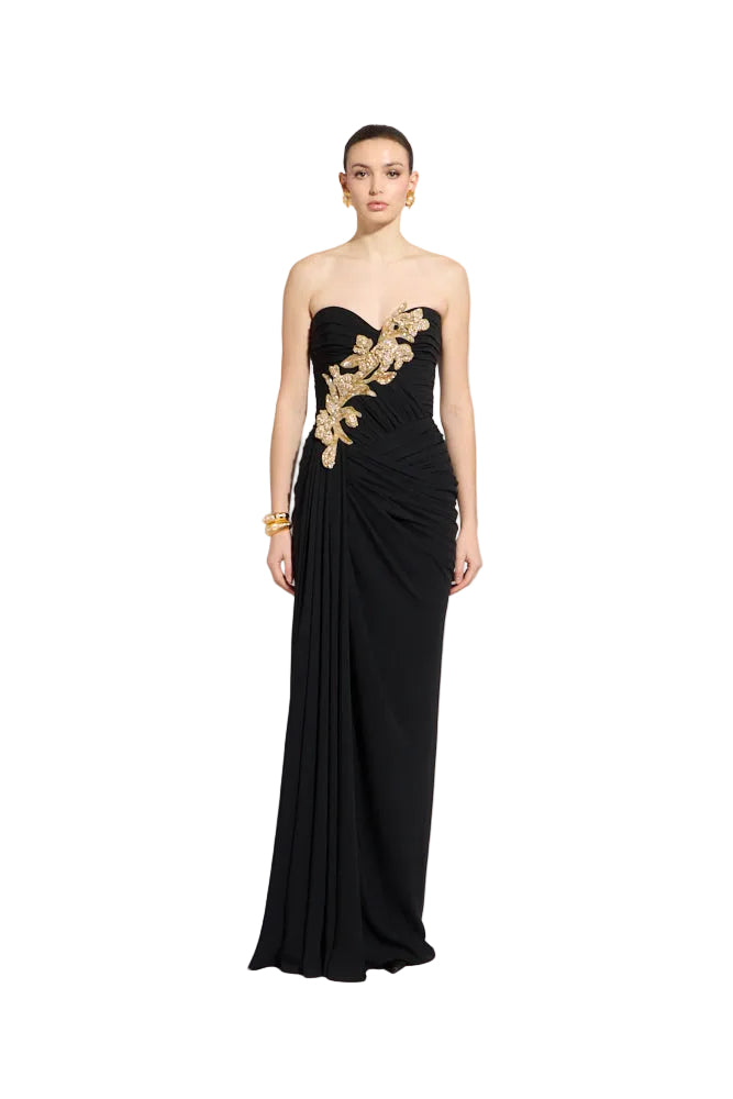 Black strapless floor-length gown with sweetheart neckline, gold-toned botanical and crystal embellishments, and draped skirt