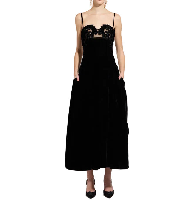 Black velvet midi dress with spaghetti straps, a sweetheart neckline, sheer bust panel, and black floral appliqué.