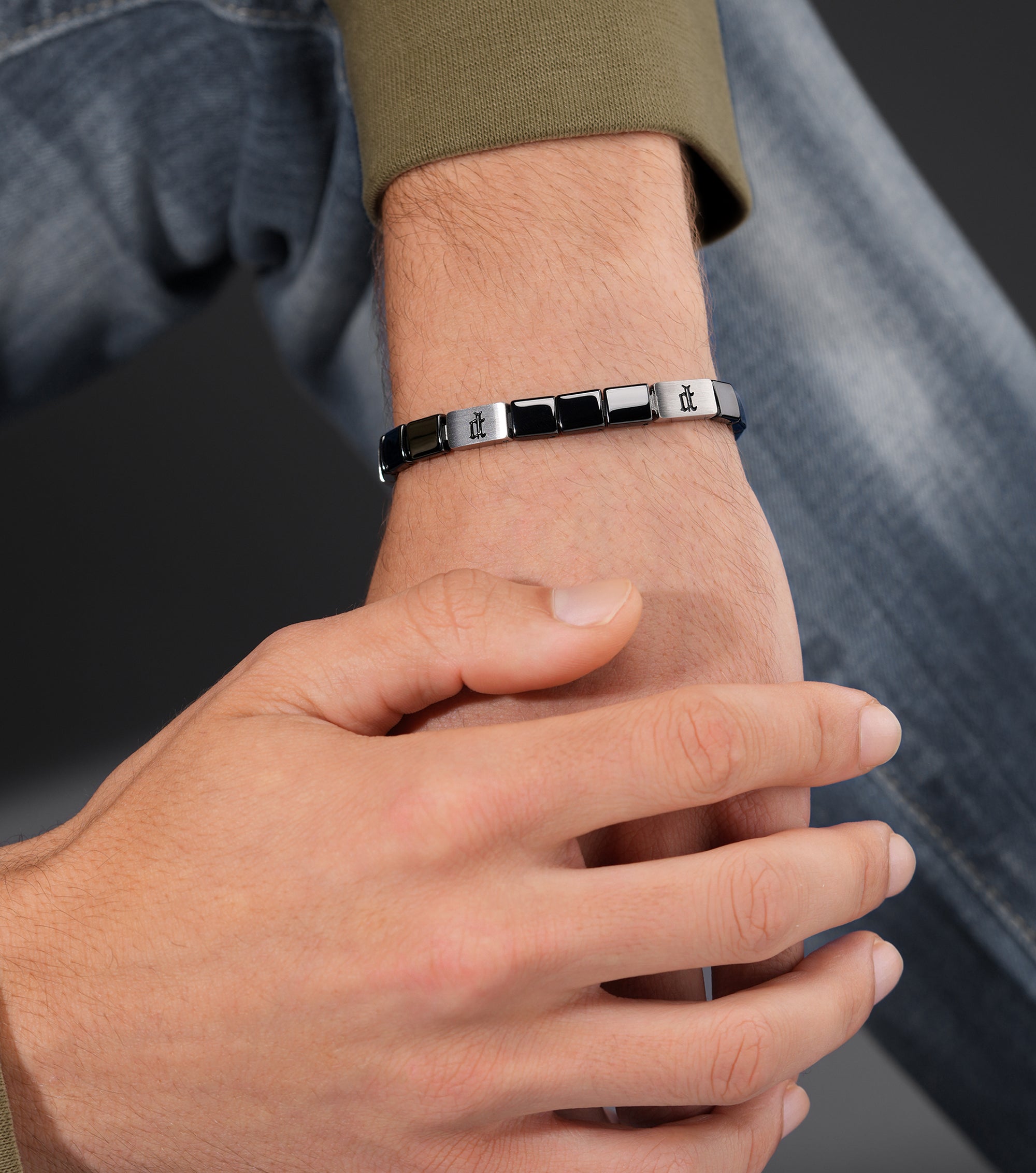 Silver-toned and black cube chain bracelet with alternating links. Some silver-toned links have an etched symbol.