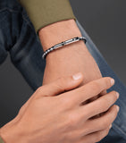Braided black and grey leather bracelet with a silver-toned bar clasp engraved 'POLICE', flanked by textured silver-toned and