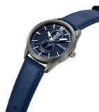 Gunmetal-toned watch with a textured blue dial, silver-toned hands/markers, a "1987" sub-dial, and a blue leather strap.