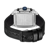 Back of a watch with a clear rectangular case, silver-toned backplate, blue crown, and black woven strap with a black buckle.