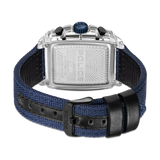 Clear rectangular watch with silver-toned back, blue crown, black pushers. Blue fabric strap with black leather lining and bl
