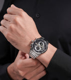 Silver-toned watch with a black dial, three sub-dials, white markers, gold-toned hands, and a silver-toned metal link bracele