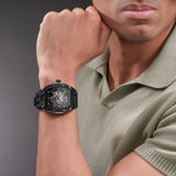 Black tonneau-shaped watch with a skeletonized Batman dial, visible gold-toned gears, and a black silicone strap.